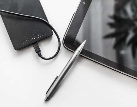 tablet, pen and external hard disk (Winchester) on a white background