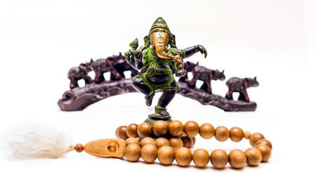 Indian Souvenirs: Bronze Ganesha, wooden beads and plastic elephants in the background on a white backgroundの写真素材