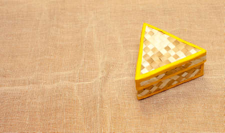 Wicker triangular box on a beige napkinの写真素材
