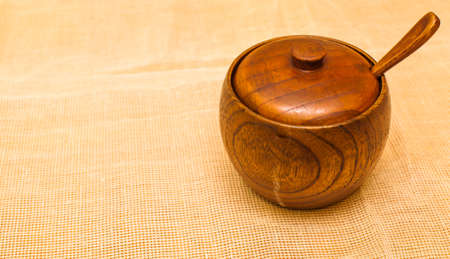 Wooden salt shaker with a spoon on a beige napkinの写真素材