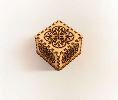 The box is made of plywood with a pattern cut by laser cutting on a white backgroundの写真素材