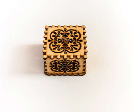The box is made of plywood with a pattern cut by laser cutting on a white backgroundの写真素材
