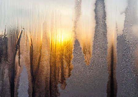 Frosty pattern on glass in the setting sunの写真素材