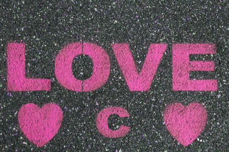 Road asphalt texture. Bitumen surface structure with painted love word.の写真素材