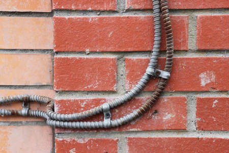 Wiring wires on red bricks building facadeの写真素材