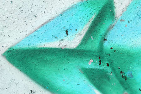 Old Weathered Graffiti Wall. Colorful Concrete Wall Fragment. Turquoise Green Arrow.の写真素材