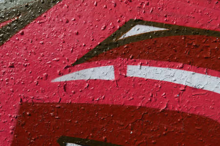 Red Old Weathered Graffiti Wall. Colorful Concrete Wall Fragment.の写真素材