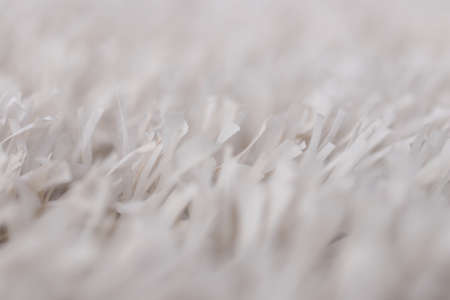 White artificial grass texture with blurred background. Modern soft tender monochrome backdrop. Exterior interior material.の写真素材