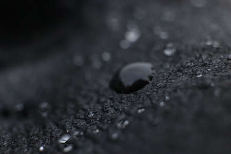 Water drops on black leather background texture. Macro Closeup.の写真素材