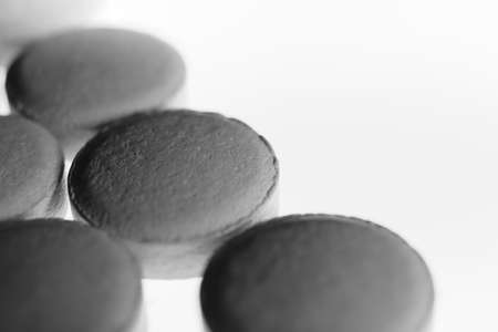 Gray Medicine Tablets. Pharmacy Pills on Isolated Background with Place for Text. Macro Closeup.の写真素材