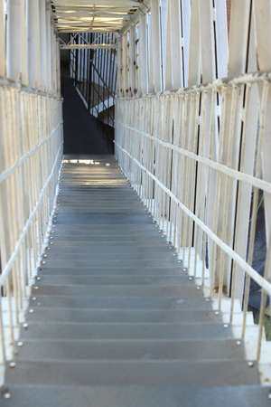 Iron ladder down protected by a cage of steel rods
