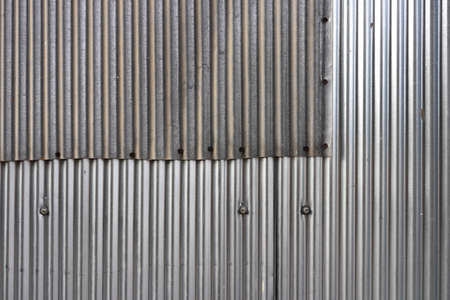 Corrugated steel fence pieces wall with nails and bolts textureの写真素材