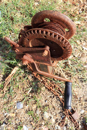 Rusty winch mechanism with a rope and a handle with a black handle