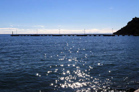 Long pier in the sea with sunshine reflection landscape.の写真素材