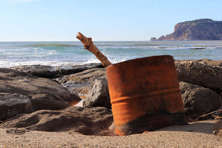 Barrel with log on the rocky beach with Bedesten Alanya fortress on background.の写真素材