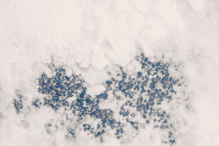 Snow on asphalt road background. Snowy trucks pattern texture. Winter frozen urban street backdrop.