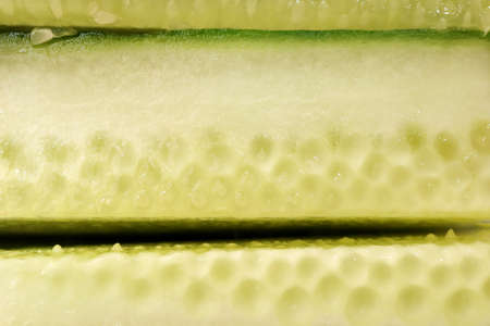Sliced cucumber pieces. Organic healthy food slices. Filling background.の写真素材