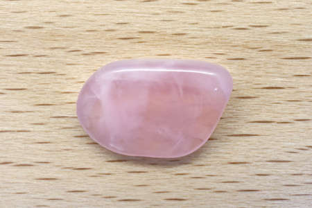 Rose quartz jewel texture on light surface background. Scarce mineral pebbles creative.