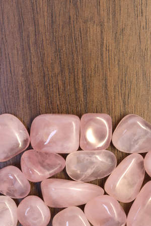Rose quartz jewel texture on light surface background. Scarce mineral pebbles creative.