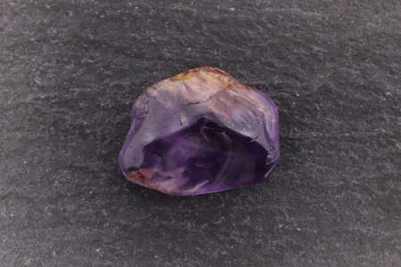 Rutilated amethyst jewel stone texture on varnished wood background. Macro closeup.