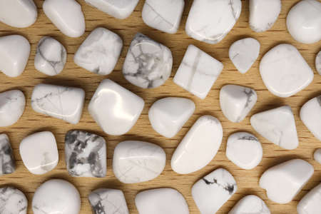 White turquoise jewel heap on light varnished wood texture. Pile mineral pebbles background.の写真素材