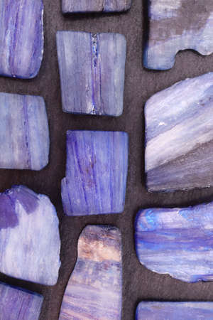 Kyanite rare jewel texture on light varnished wood background. Scarce mineral pebbles nature...