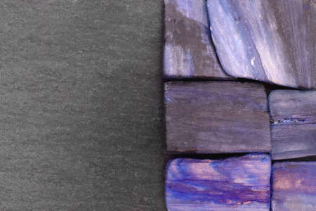 Kyanite jewel stone texture in tweezers on light surface background. Macro closeup.