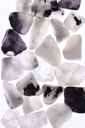 Moon stone heap jewel on brown varnished wood texture. Pile mineral pebbles background.の写真素材