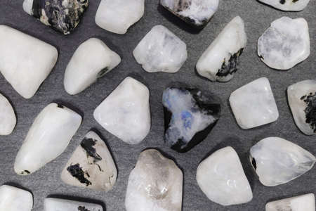 Moon stone heap jewel on half white light texture. Pile mineral pebbles background. Place for text.の写真素材