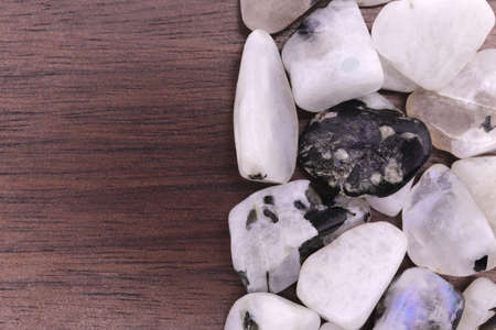 Moon stone heap jewel on half white light texture. Pile mineral pebbles background. Place for text.の写真素材