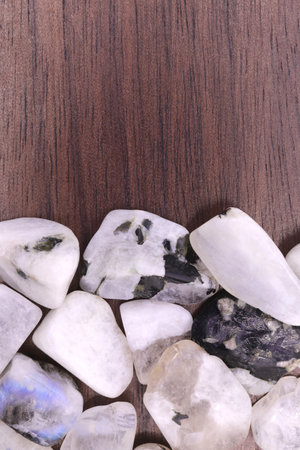 Moon stone heap jewel on half white light texture. Pile mineral pebbles background. Place for text.の写真素材