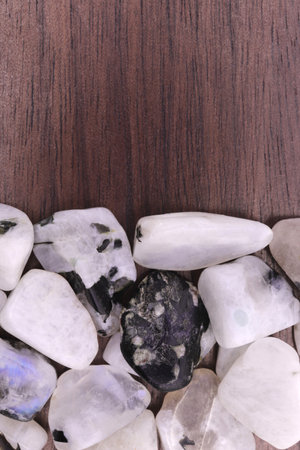 Moon stone random heap jewel on black stone texture. Pile mineral pebbles background.の写真素材