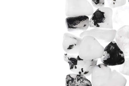 Moon stone heap jewel on half white light texture. Pile mineral pebbles background. Place for text.の写真素材