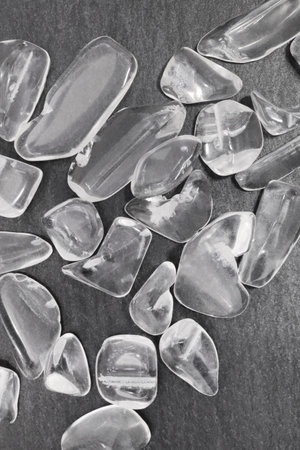 Clear quartz jewel heap on wood fiber circles background. Pile mineral pebbles texture.の写真素材