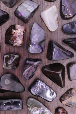 Sugilite jewel stone texture on black stone background. Macro closeup.