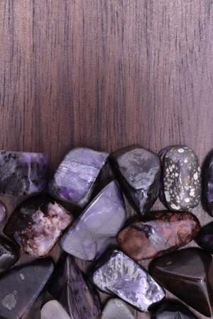 Sugilite jewel stone texture in tweezers on dark background. Macro closeup.の写真素材