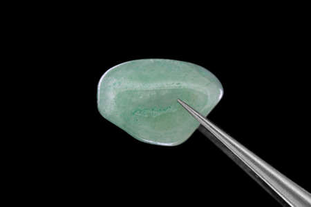 Green Aventurine rare jewel on brown varnished wood texture. Sparse mineral pebbles background.の写真素材