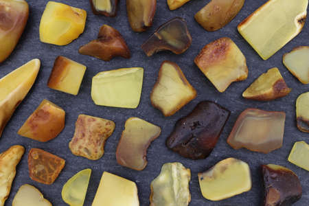 Amber rare jewel stones texture on black stone background