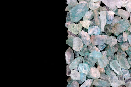 Apatite jewel stone texture on light varnished wood background. Macro closeup.