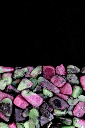 Ruby zoisite rare jewel stones texture on brown varnished wood background.の写真素材