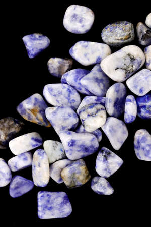 Sodalite jewel stone texture on black stone background. Macro closeup.の写真素材