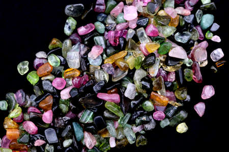 Tourmaline different color jewel stone texture on black stone background. Macro closeup.の写真素材
