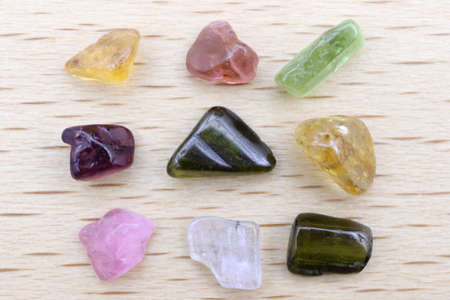 Tourmaline different color jewel stone texture on wood background. Macro closeup.の写真素材