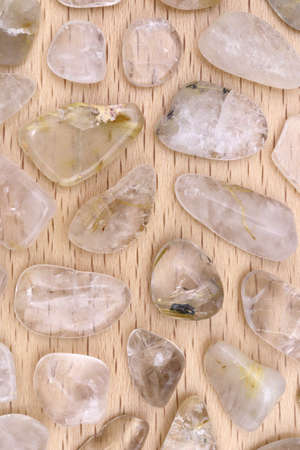 Rutilated quartz heap jewel stones texture on wooden backgroundの写真素材