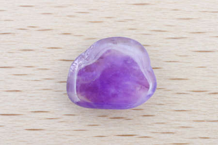 Amethyst jewel stone texture on brown varnished wood background. Macro closeup.の写真素材