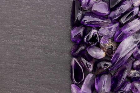 Amethyst jewel stone texture on brown varnished wood background. Macro closeup.の写真素材