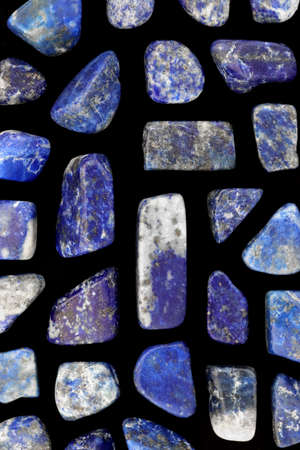 Lapis lazuli jewel stone texture on brown varnished wood background. Macro closeup.