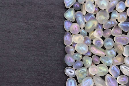 Shimmerstone heap jewel stones texture on half brown varnished wood background. Place for text.