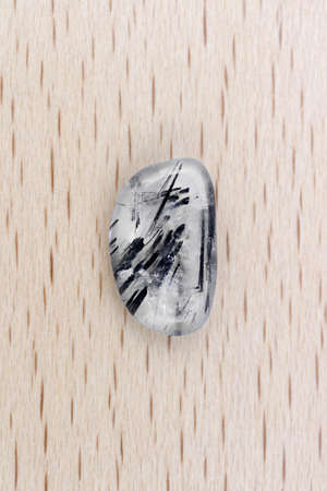 Tourmalinated quartz jewel stone texture on black stone background. Macro closeup.の写真素材
