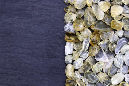 Citrine jewel stone texture in tweezers on white light isolated background. Macro closeup.の写真素材